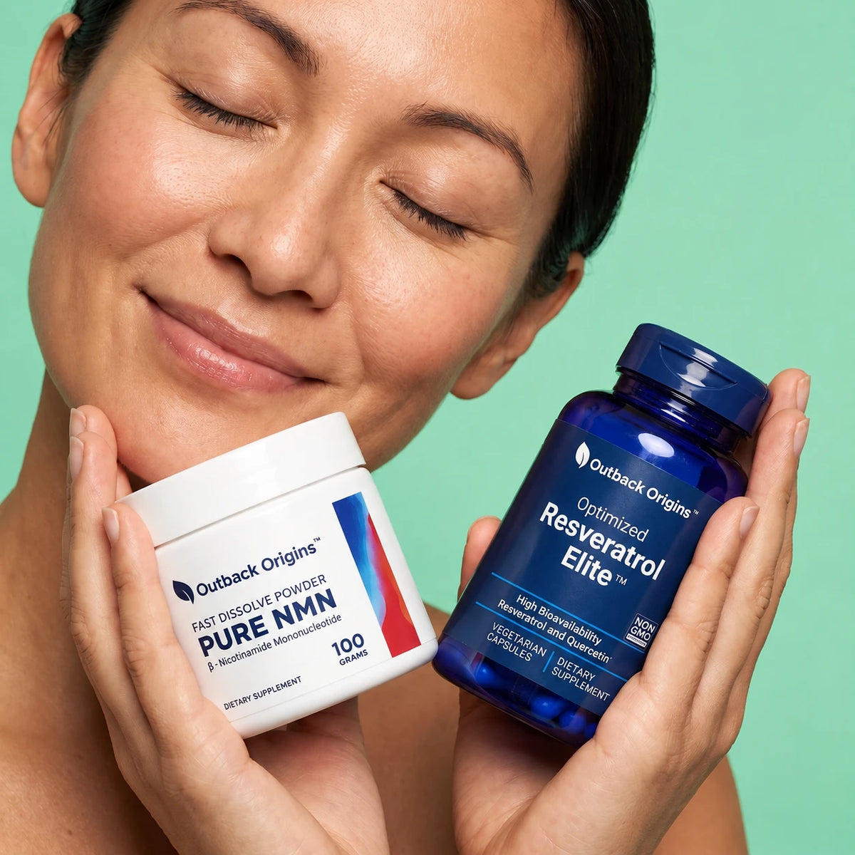 both Outback Origins supplement containers in hands against a mint green background: a white jar labeled Pure NMN and a blue bottle labeled Resveratrol Elite.